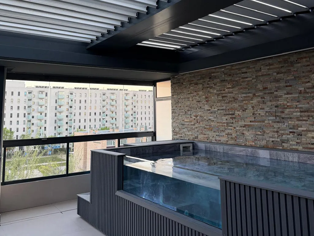 Terraza con pérgola inteligente bioclimática NUMA en otoño, lamas orientadas para captar luz y proteger del viento
